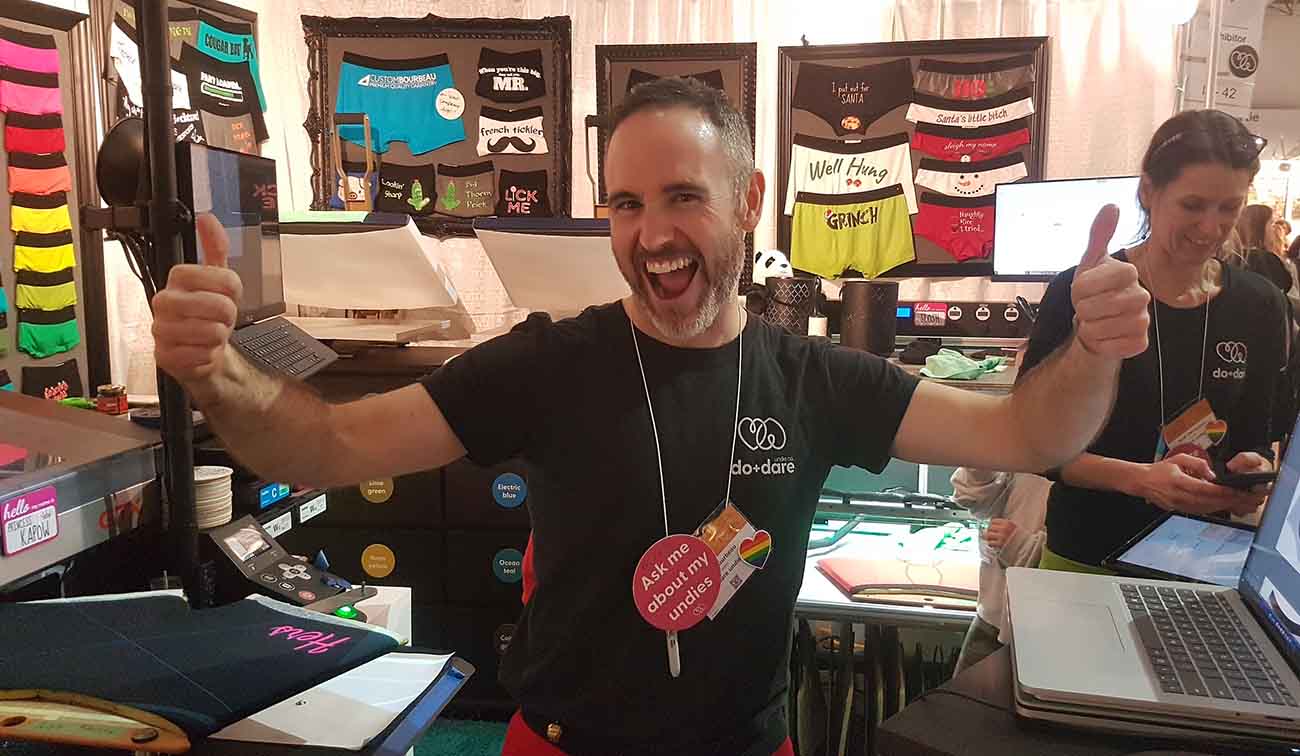 do+dare undie co. at the one of a kind spring show in toronto - rob with thumbs up designing + inking underwear live on demand