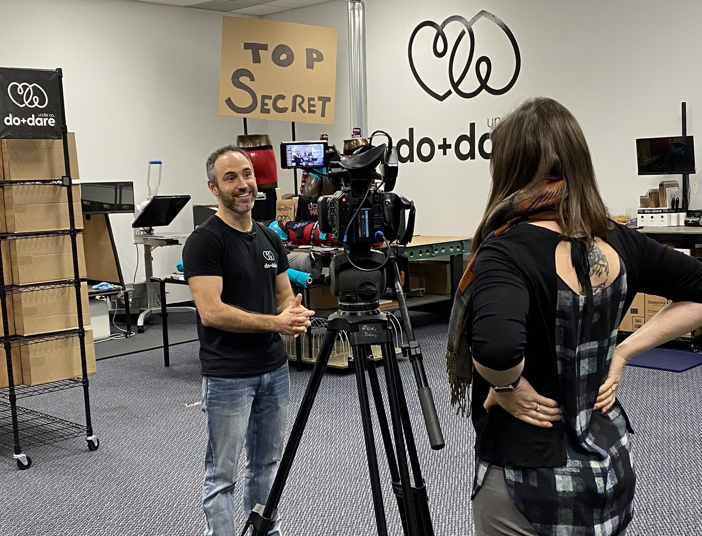 rob in front of video camera in the do and dare undie co studio - with nikki wesley interviewing him