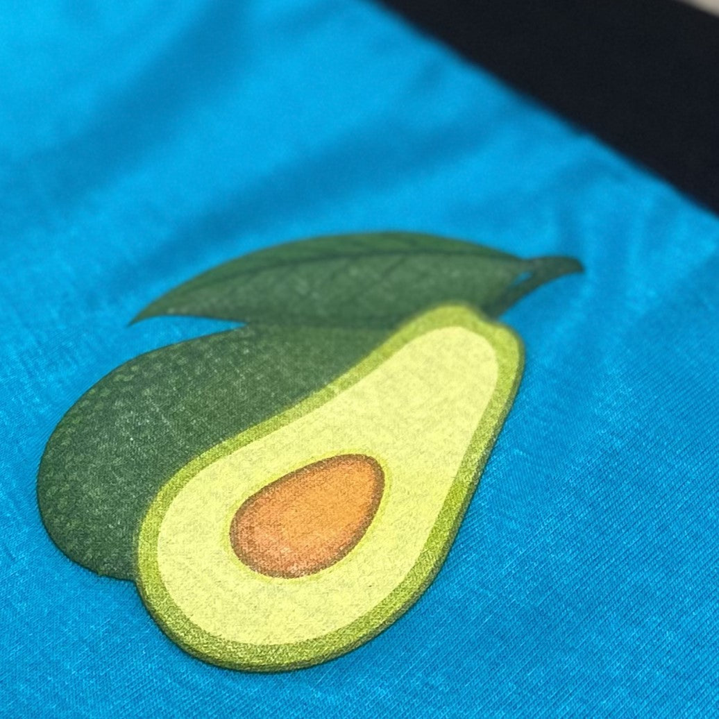 closeup image of a teal undie, ink'd with an avocado sliced open