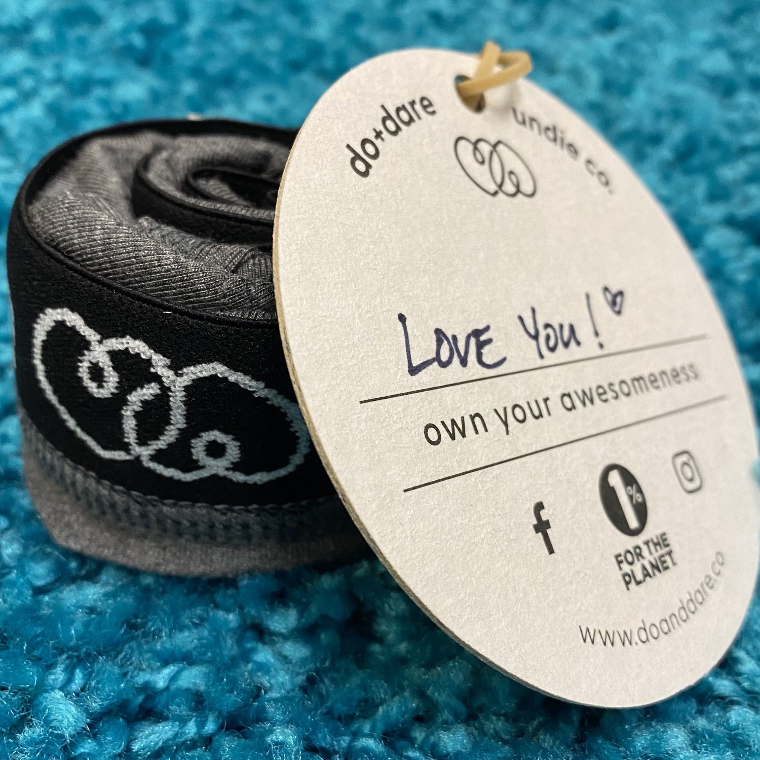 underwear rolled into a puck with a coaster tag - on it is written "love you!" 
